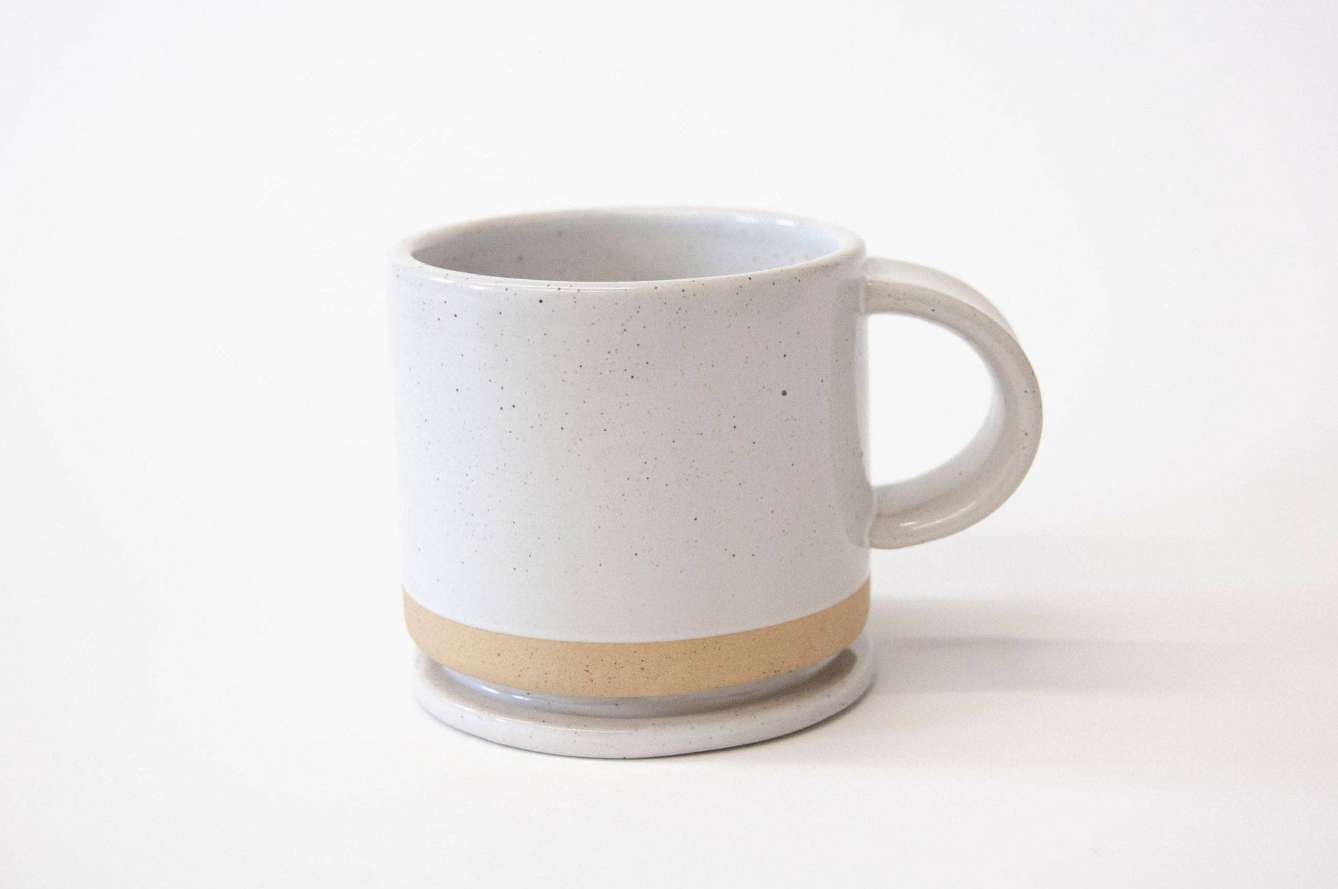 White ceramic mug with beige accent on a white background