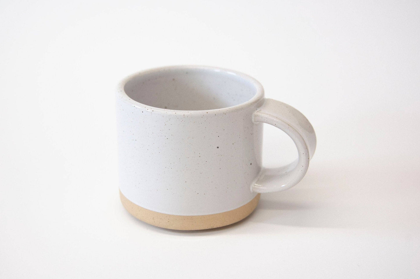 White ceramic mug with a beige base on a white background