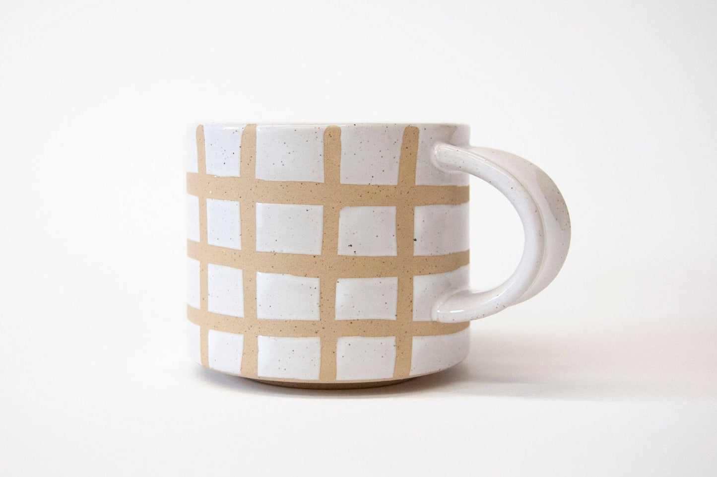 Ceramic mug with beige checkered pattern on a white background